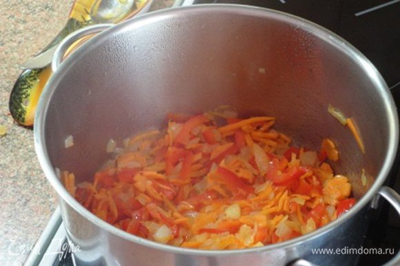 В большой кастрюле разогреть масло. Добавить морковь, чеснок, лук и перец, обжарить до золотистого цвета. Добавить тмин и порошок красного перца, ½ ч. ложки соли. Готовить 1 минуту.