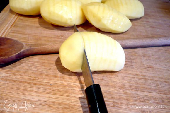 Разогреем духовку до 200 градусов. Картофель очистим. Теперь надрежем каждый картофель поперек через каждые 5 мм, прикладывая при резке к каждой картофелине деревянную ложку и надрезая до тех пор, пока нож не коснется ложки. Каждую картофелину смазываем оливковым маслом (нам потребуется примерно 3 ст.л.) и посыпаем солью.