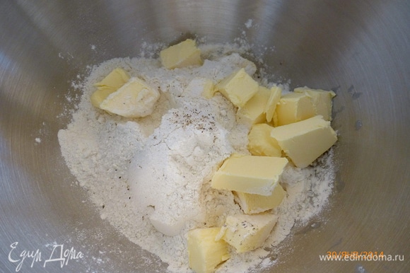 Готовим тесто. К муке добавляем сахар, соль, перец. Холодное сливочное масло режем на небольшие кусочки. Перетираем мучную смесь с маслом до образования крошек.
