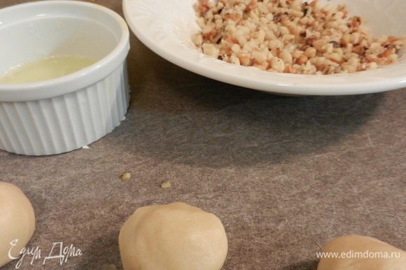 Сформировать шарики (2 ч. л. на каждый). Макать шарики поочередно сначала в взбитый вилкой белок, потом опускать в измельченные орехи.