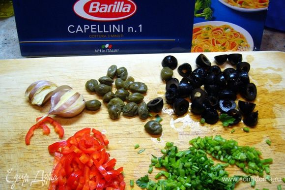 Т.к. процесс приготовления пойдет быстро, приготовим все ингредиенты: чеснок раздавим прямо в кожуре, оливки и перец чили порежем, нарежем стебли петрушки. Поставим кипятиться воду для спагетти.