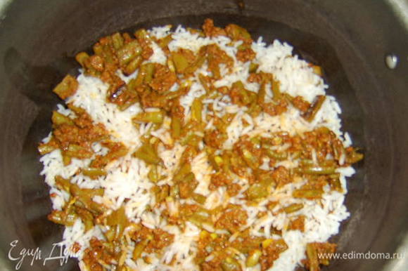 На дно кастрюли с толстым дном налить 2 ст.л. растительного масла без запаха и нагреть его, потом укладываем слоями рис и фасоль с фаршем: вначале небольшой слой риса, затем немного фарша с фасолью и тд.