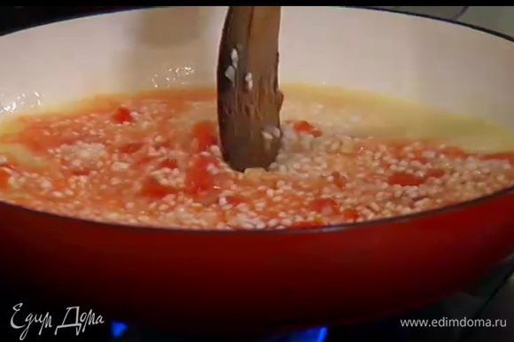 В середине приготовления, примерно через 10 минут, добавить помидоры в собственном соку, затем по одному половнику влить оставшийся бульон, время от времени помешивая ризотто.