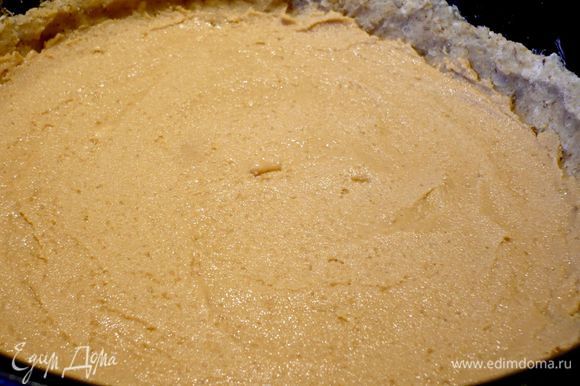 Для арахисового крема. В блендере сначала измельчаем немного сахар, вводим орехи, перемешиваем до мелкой крошки и добавляем масло, вымешиваем в блендере до кремовой консистенции. Нам потребуется 175 г арахисового крема. Равномерно выкладываем его на тесто.