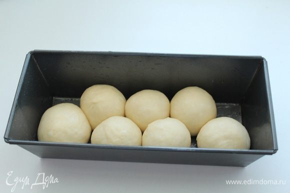 Когда тесто увеличится вдвое, обмять его и разделить на 16-20 шариков. Смазанными растительным маслом руками,выложить в смазанную маслом форму для выпечки половину шариков.