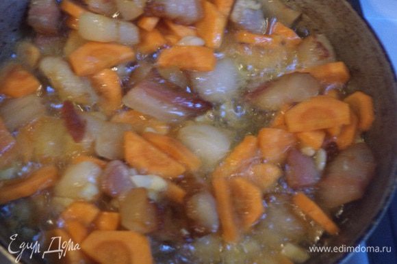 На растительном масле обжарить бекон, добавить морковь и чеснок, обжаривать 3 - 5 минут, до подрумянивания.