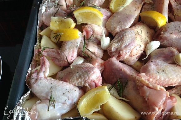 На картофель выложить курицу, чеснок, лимон, приправить тимьяном, листочками розмарина. Посолить и поперчить.
