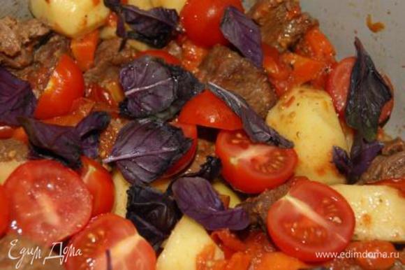 Добавить картофель, черри и листья базилика к мясу, готовить на среднем огне еще 20 минут