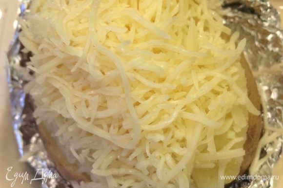 Готовый картофель надрезаем не до конца пополам, немного раздвигаем в стороны половинки, так чтобы они не развалились. В середину кладем кусочек сливочного масла, солим и посыпаем сыром. Отправляем в духовку по гриль, чтобы появилась румяная корочка.