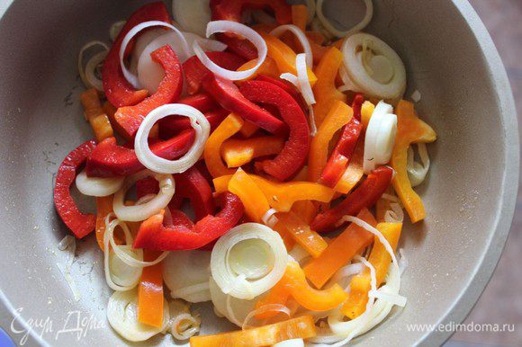 Порей (белую часть) нарезать тонкими полукольцами, болгарские перцы (у меня красный и оранжевый) нашинковать средними полосками. На оливковом масле обжарить овощи в течение 5 минут.