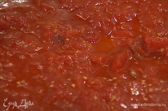 В ту же сковороду выложить консервированные помидоры, добавить измельченный пеперончино, сахар и прогревать, перемешивая, чтобы получился однородный соус.