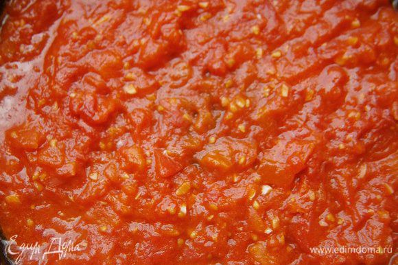 В сковороде раскалить 2 ст. л. растительного масла, добавить нарезанные помидоры, чеснок и готовить, помешивая, 2 - 3 минуты.