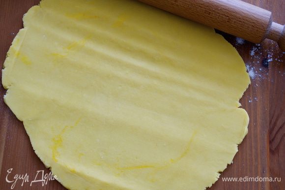 Включить духовку на 190 С. Тесто достать из холодильника и раскатать в пласт толщиной примерно 0.5 см. С помощью скалки перенести тесто в подготовленную форму для выпечки (24 см).