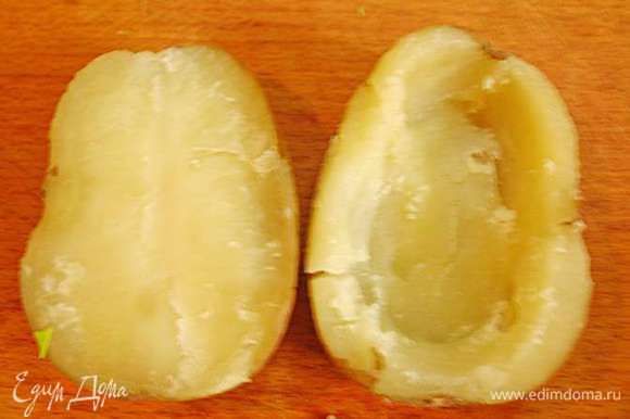 С готового картофеля слить воду, дать немного остыть. Разрезать картофель пополам. Вынуть серединку оставляя стеночки толщиной 5 - 10 мм. У нас получаются лодочки.