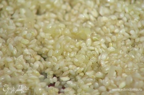 Рис всыпать к луку с чесноком и сделать тостатуру: помешивая прогревать 1–2 минуты, чтобы рис стал прозрачным.