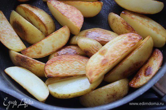 Картофель хорошо помыть, не чистить. Нарезать крупными дольками. Разогреть масло в сковороде и обжарить картофельные дольки на сильном огне до золотистой корочки. Переложить на тарелку.