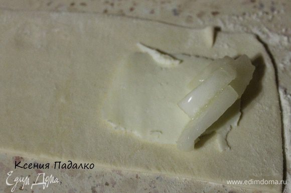 Тесто разморозить и раскатать слегка в длинные прямоугольники. На край теста кладем ломтик сыра.