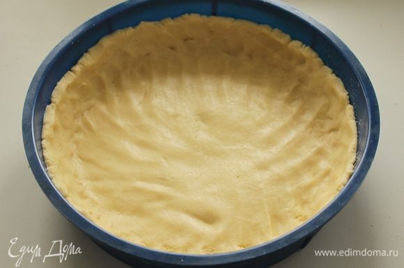 Выложите тесто в разъемную форму диаметром 24-26 см и сформируйте бортики.