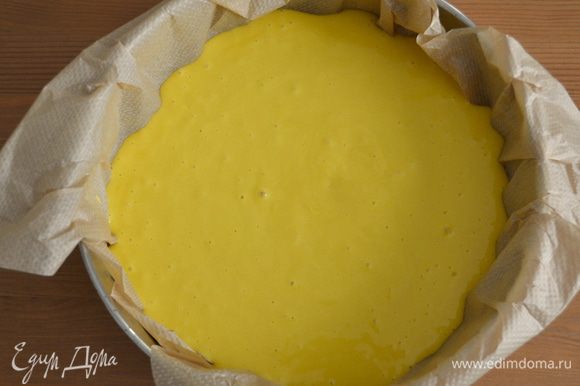 Форму для выпечки (диаметр 24 см) застелить пекарской бумагой и выложить тесто.