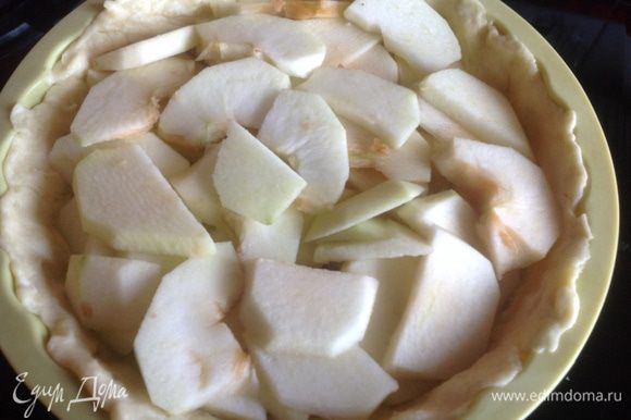 Яблоки очистите, удалите сердцевину, нарежьте тонкими пластинами. Разложите яблоки на тесто.