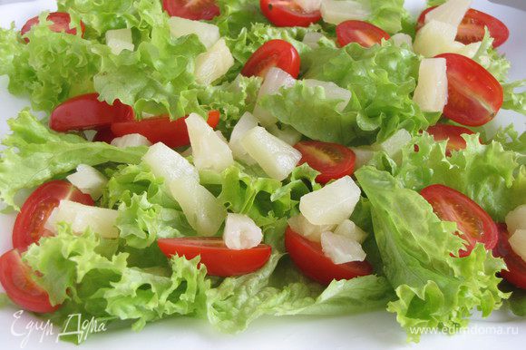 Салатные листья нарвать руками и выложить на блюдо. Можно использовать любой зеленый листовой салат, в том числе и пекинскую капусту. Добавить ананасы и помидоры.