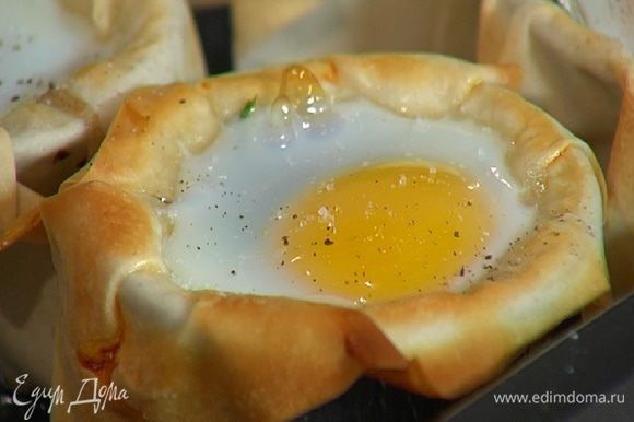 Запекать яйца в разогретой духовке 10 минут, затем посолить и поперчить.