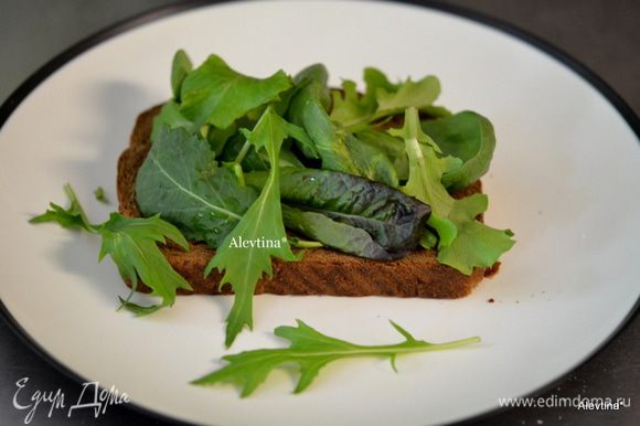 На хлеб свежий или разогретый в тостере выложить мягкое масло по желанию, затем свежие листья салата.