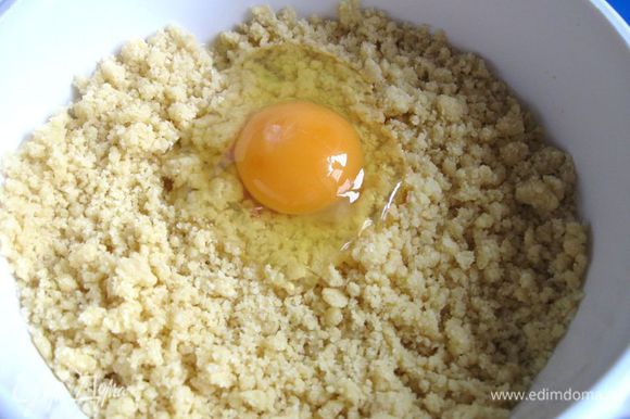 Добавить охлажденное сливочное масло, нарезанное кубиками. Порубить в мелкую крошку. Добавить яйцо и перемешать. Собрать тесто в шар, завернуть в пищевую пленку и убрать на 1 час в холодильник.