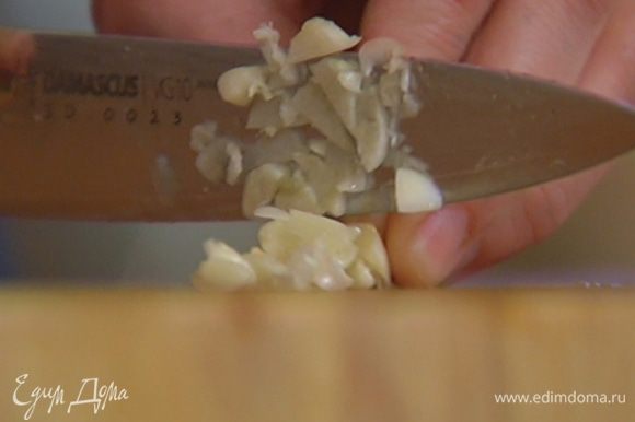 Чеснок почистить, раздавить плоской стороной ножа, затем мелко порубить и добавить к овощам.