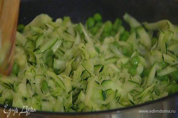 Зеленый горошек и натертый цукини выложить в сковороду с луком и чесноком, посолить, поперчить, перемешать и прогревать на медленном огне несколько минут.
