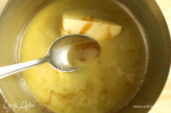 75 г масла и мёд нагреть в кастрюле на маленьком огне и вылить в миску к смеси.