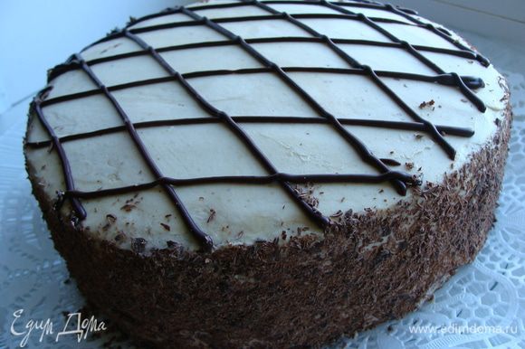 20 грамм шоколада натрем на крупной терке, обсыпем бока торта. Топпинг поместим в корнетик, нанесем узор.
