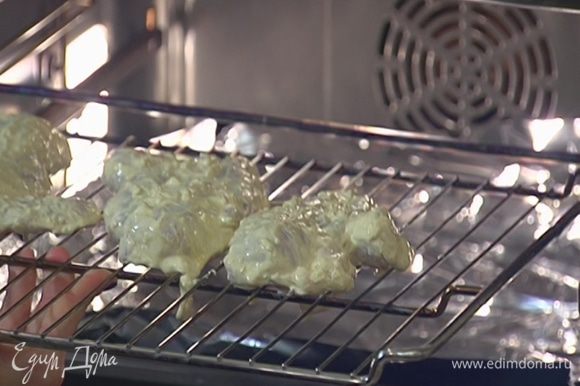 Замаринованные куриные грудки выложить на решетку, смазать остатками маринада и поместить в духовку на средний уровень.