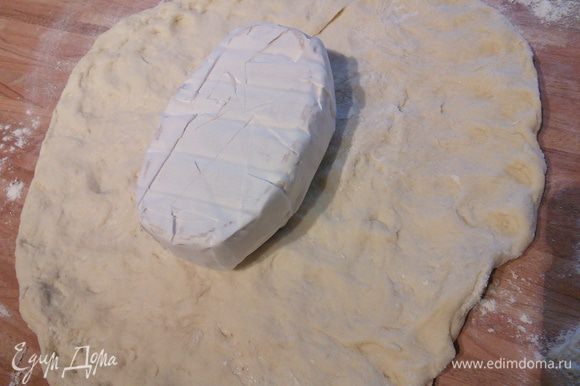 В любом случае выложите тесто на посыпанную мукой рабочую поверхность. Распластайте его руками. Выложите сыр ( он должен быть продолговато-овальной формы).