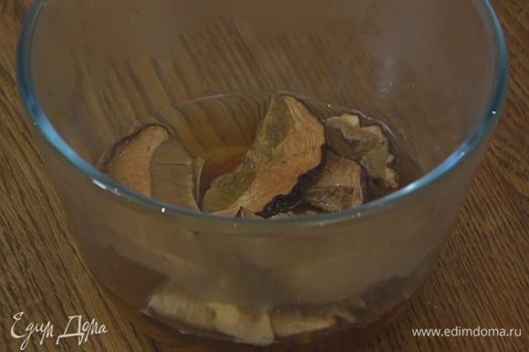 Сухие грибы замочить в кипятке, дать настояться, затем слить воду через сито в отдельную посуду.