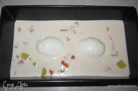 В форму на дно выкладываем салат на 1/3, заливаем соус. Затем кладем очищенные вареные яйца (лучше если яйца домашние, ярче желтки и красивее смотрится). Потом снова кладем салат.