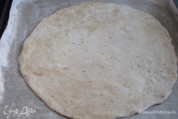 Раскатать тесто в круг, толщина примерно 0,5 см. Перенести его с помощью скалки на противень, застеленный промасленной пекарской бумагой.