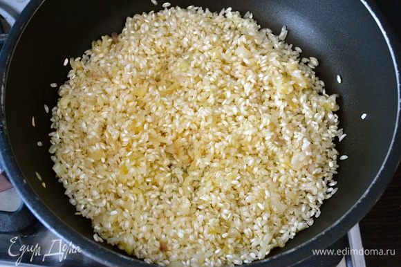 Добавить в сковороду рис. Предварительно не промывать! В данном рецепте используется рис сорта Бальдо (Baldo), за отсутствием этого сорта, можно использовать рис карнароли. Перемешать рис с луком и дать обжариться буквально пару минут, помешивая.