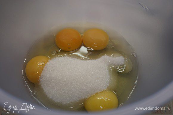 Приготовим бисквит. Включить разогреваться духовку до 200 ° С. Противень застелить пергаментом, смазанным маслом. Взбейте 2 яйца, 2 яичных желтка и сахар в течение 5-7 минут до увеличения массы в 2-3 раза.