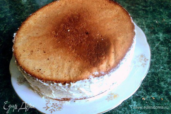Накрыть вторым коржом. Смазать корж половиной крема, накрыть третьим коржом и оставшимся кремом смазать бока торта.