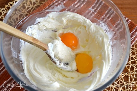 Яйца разделить на желтки и белки. Последние временно отставить в сторону, а желтки добавить в сырную массу и размешать все до однородности.