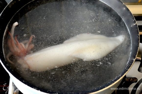 В кастрюлю налить воду и дать закипеть. Положить столовую ложку соли. Варить тушки кальмаров буквально по 1 минуте, помещая их поочередно в кастрюлю с кипящей водой.