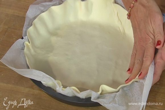 Форму для выпечки выстелить пищевой бумагой, выложить тесто так, чтобы получились бортики, и часто наколоть вилкой.