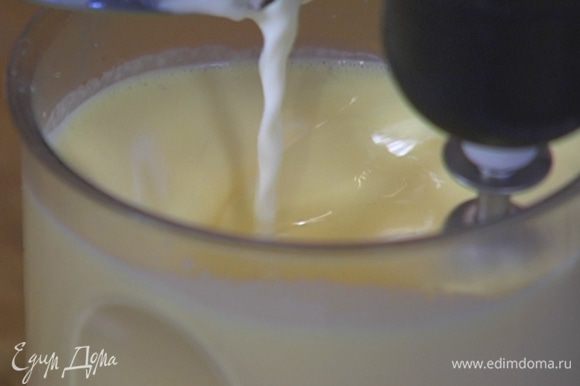Продолжая взбивать на медленной скорости, тонкой струйкой влить горячее молоко со сливками.