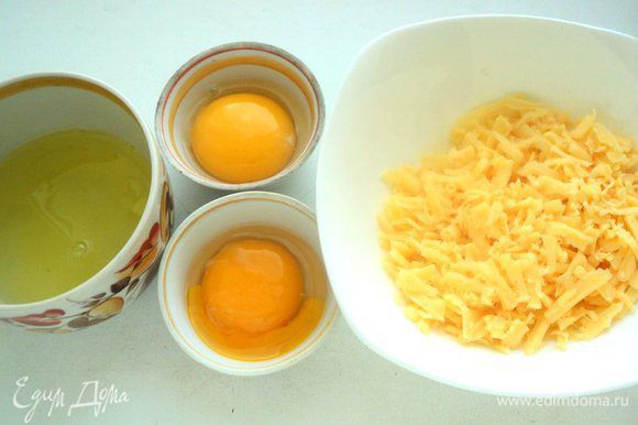 Яйца разделить на белки и желтки. Желательно, чтобы желтки остались целыми. Сыр натереть на терке.