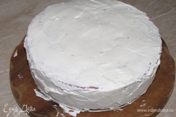 Взбить оставшиеся сливки, постепенно добавляя сахарную пудру, и обмазать торт со всех сторон.