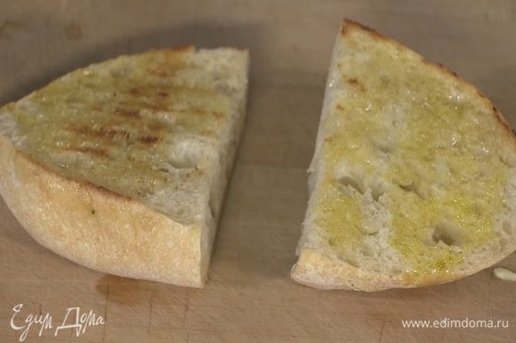 Хлеб сбрызнуть оставшимся оливковым маслом и обжаривать на сковороде, где жарилась котлета, до появления румяных полосок.
