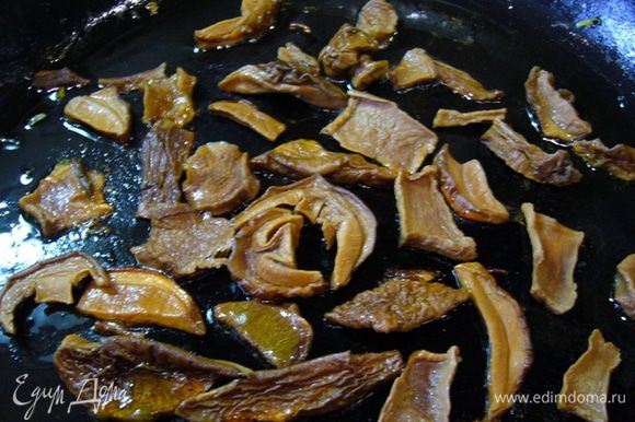 Разогреть в сковороде оставшееся оливковое масло, на сильном огне быстро обжарить грибы.