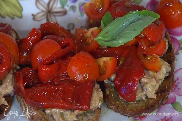 На обжаренный хлеб выложить тунца с оливками и каперсами, сверху поместить запеченный перец с помидорами, украсить замаринованным луком и листьями базилика.