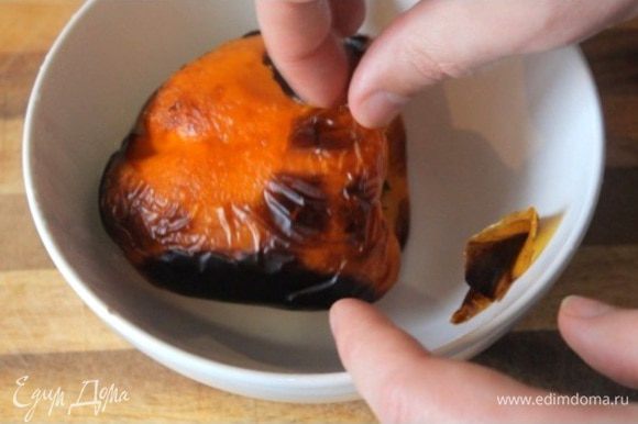 Запекаем сладкий перец под грилем до черноты. Далее кладем его в тарелку и накрываем пищевой пленкой, чтобы отстала кожура. Спустя 5 минут снимаем с перца кожуру.